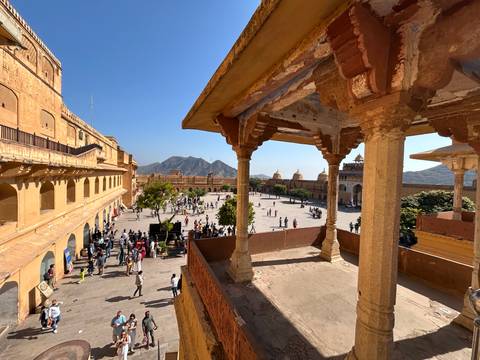      An open courtyard of a fortress with people walking.
  