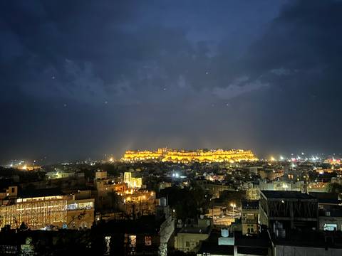       A cityscape at night with a brightly lit fort.
  