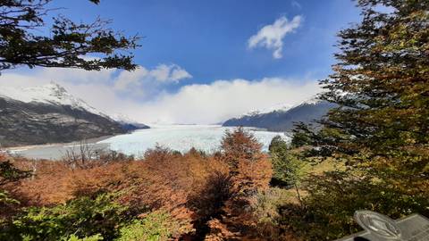 A glacier with autumn foliage and mountains.