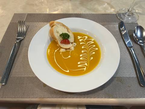       A bowl of soup with decorative bread and garnish.
  