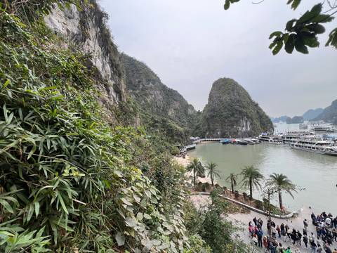       A scenic view of a bay with boats and limestone cliffs.
  