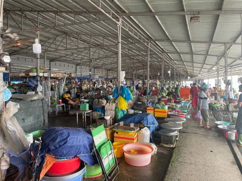       Inside a bustling market with vendors and produce.
  