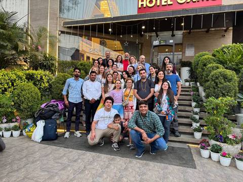 Group of people posing in front of a building entrance.