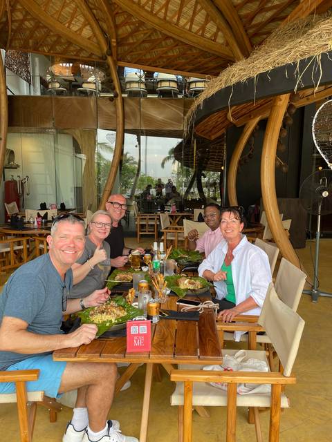       Group dining at a restaurant with wooden decor.
  