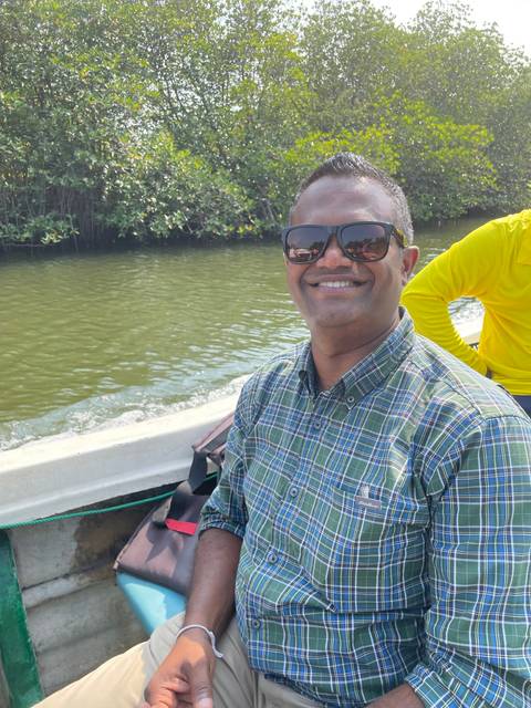       Man smiling on a boat in a river.
  