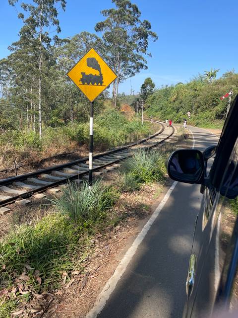       Railroad tracks running alongside a road.
  