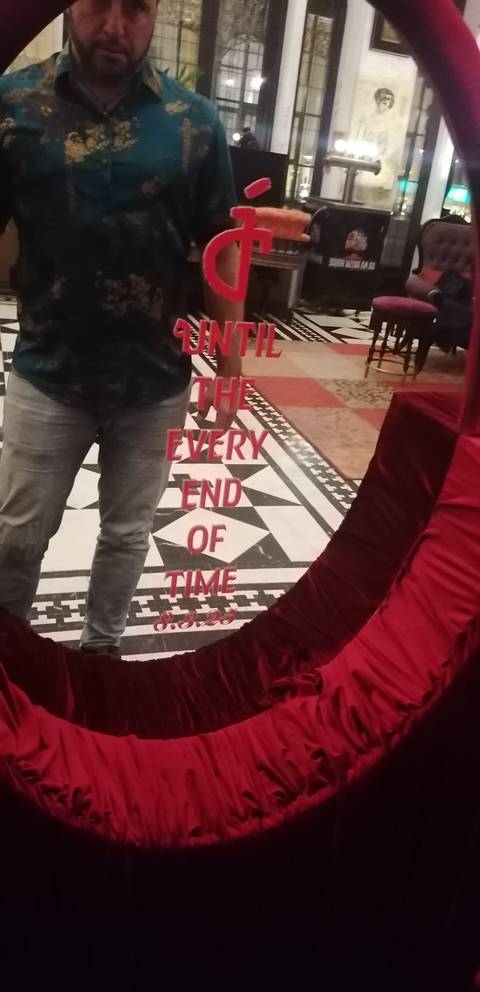       Mirror reflection with text and a person partially visible.
  