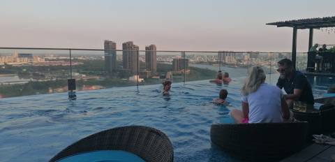 Infinity pool with a view of city skyline at dusk.