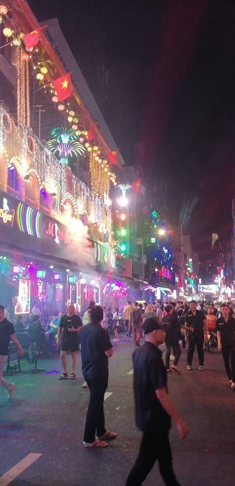       Vibrant and busy night market with colorful lights.
  