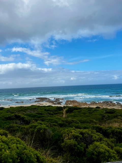 Scenic view of the rocky shoreline and ocean under a blue sky.