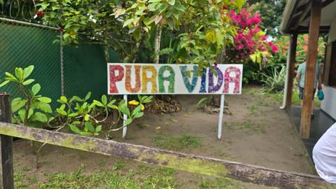 Sign 'PURA VIDA' in a garden setting.