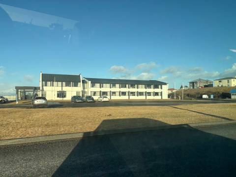       Modern building with several parked cars in front.
  