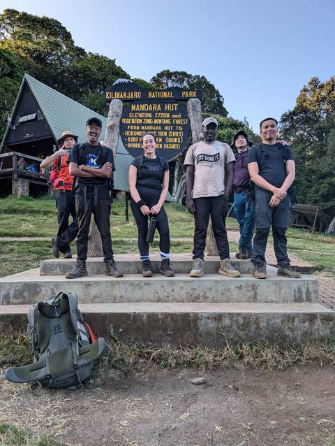 Posed group standing by a national park sign in Tanzania.