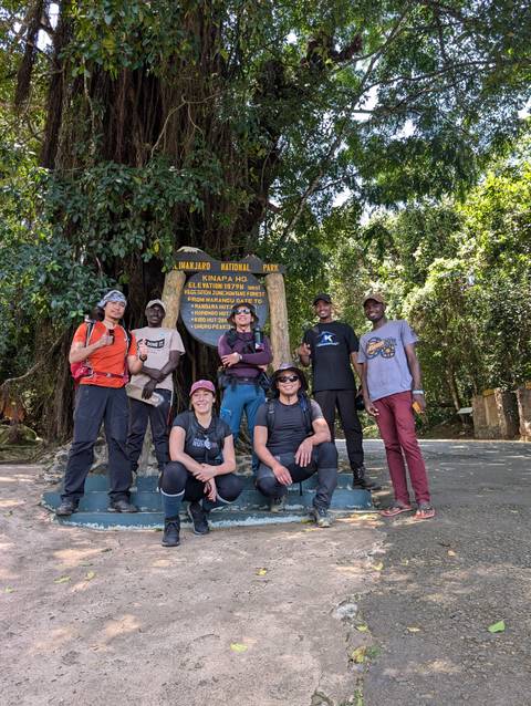 Group of trekkers at Kilimanjaro National Park entrance.