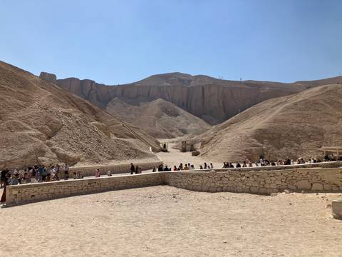 Tourists lined up in a rocky desert landscape.