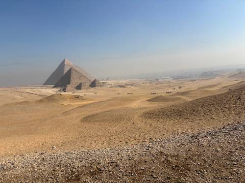 Wide view of the Pyramids of Giza with surrounding desert.