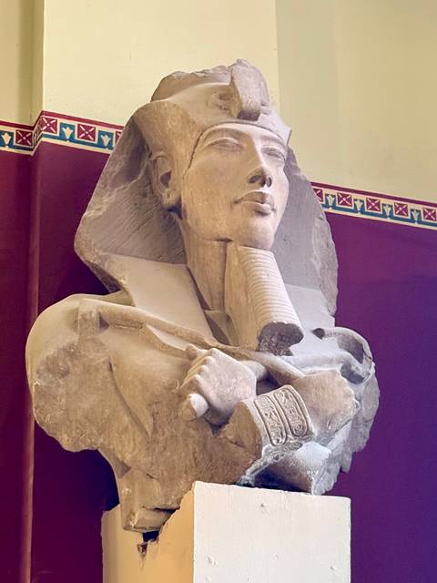       Statue of Pharaoh in a museum setting.
  