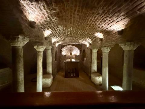       Underground stone chamber with columns and arches.
  