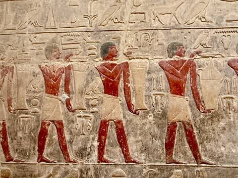       Ancient Egyptian wall carvings of figures.
  