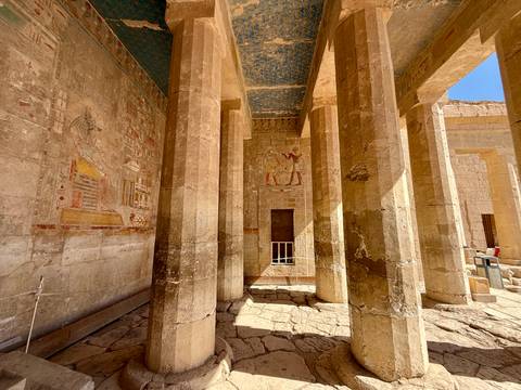       Temple interior with decorated pillars and inscriptions.
  