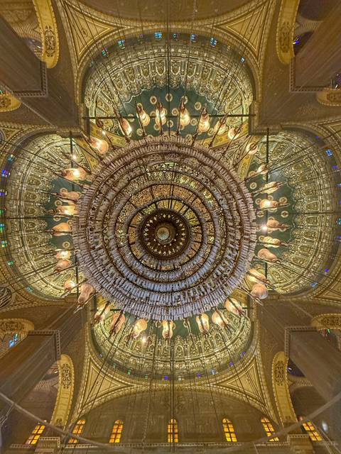       Intricate chandelier in an ornately decorated ceiling.
  