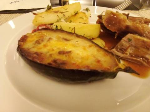 Close-up of a plate with eggplant, potatoes, and meat dish.
