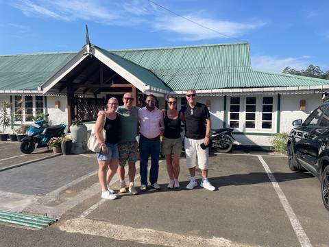       Group photo of people standing outside a colonial-style building.
  