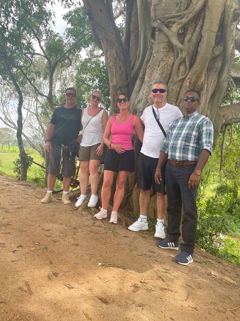       Group of people standing by a tree.
  