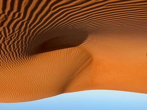 Golden sand dunes under a clear blue sky.