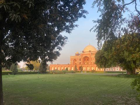 Mausoleum set in a lush garden with trees framing the view.