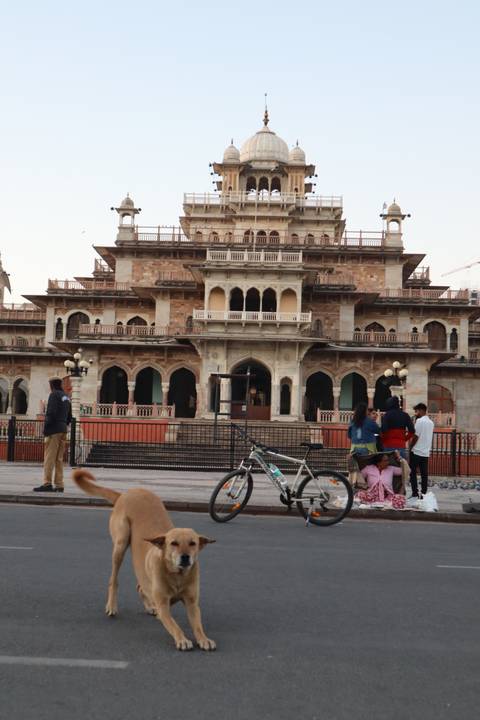 Historical building with intricate architecture surrounded by people.