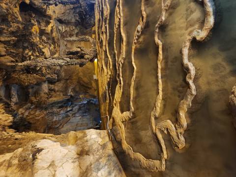       Rock formations in a cave with artificial lighting.
  