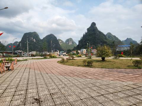      Park with mountains and a paved walkway.
  