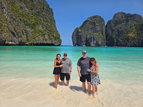 Group of people standing on a tropical beach.