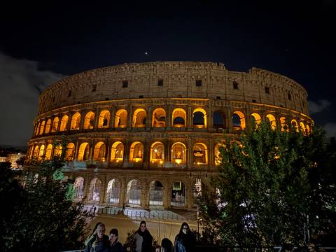       Colosseum at night illuminated with golden lights.
  