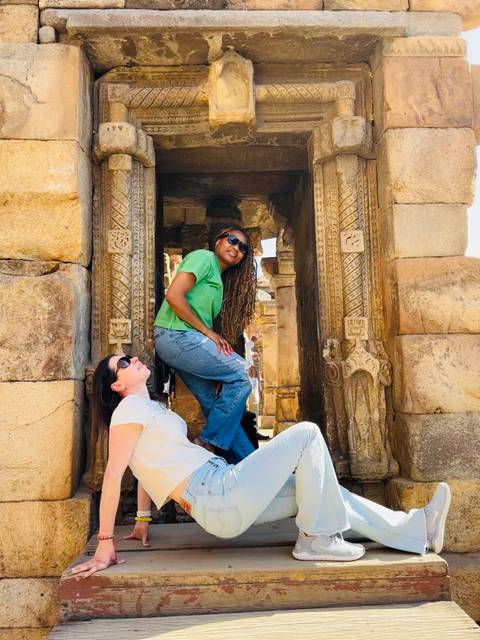 Two women posing inside an ancient ruin.