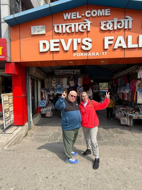 Two people posing in front of a souvenir shop.