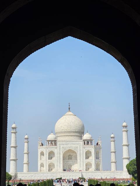       View of the Taj Mahal through an archway.
  