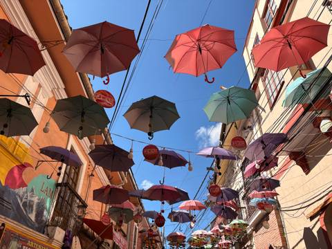 Colorful umbrellas hanging above a street.