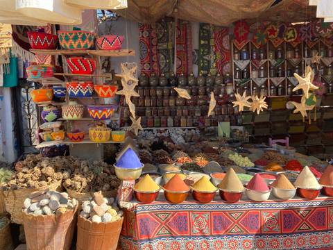 A colorful market stall with spices and crafts displayed.