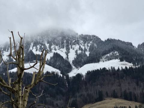 Snow-dusted mountains under a cloudy sky.