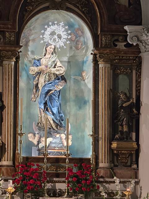 Ornate religious statue with a painted backdrop.