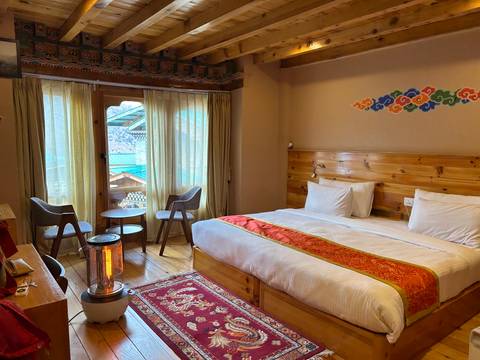 Well-decorated hotel room with a large bed and seating area.