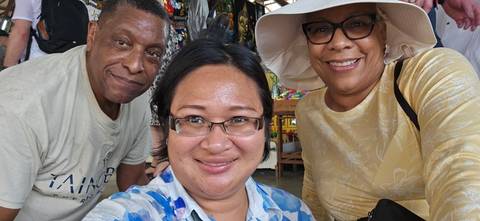 Three smiling people posing for a photo indoors.