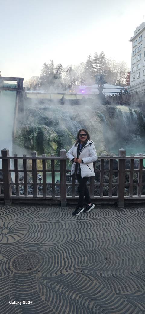 Person posing by a steaming hot spring.