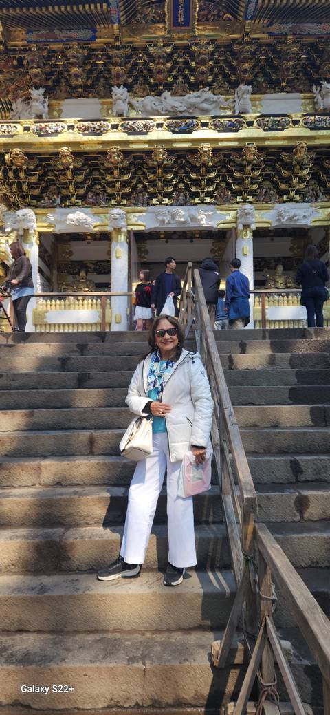 Person at a staircase with a shrine in the background.