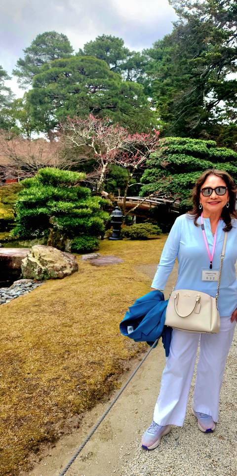 Person in a garden setting with traditional Japanese landscaping.