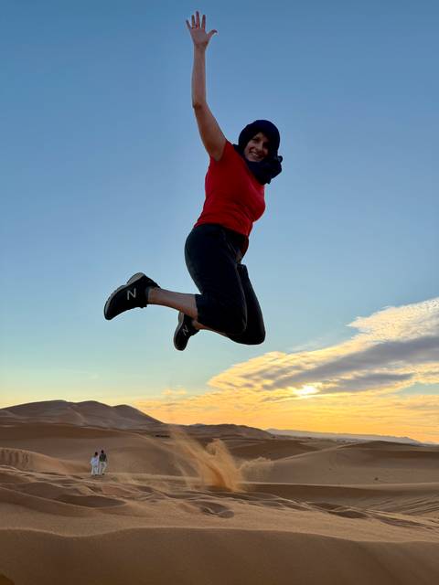       Silhouette of a person jumping against a sunrise or sunset sky.
  