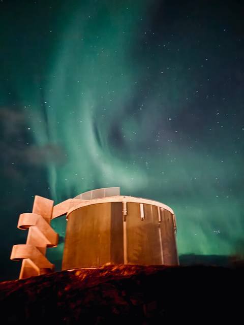 Northern lights over a futuristic building.