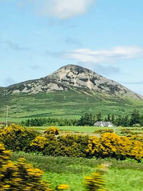       Green mountain landscape with house.
  